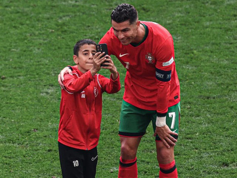 Cristiano Ronaldo taking photo with a pitch invader