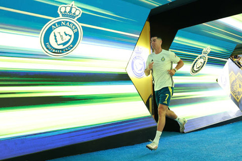 Cristiano Ronaldo running in front of Al Nassr screen wall